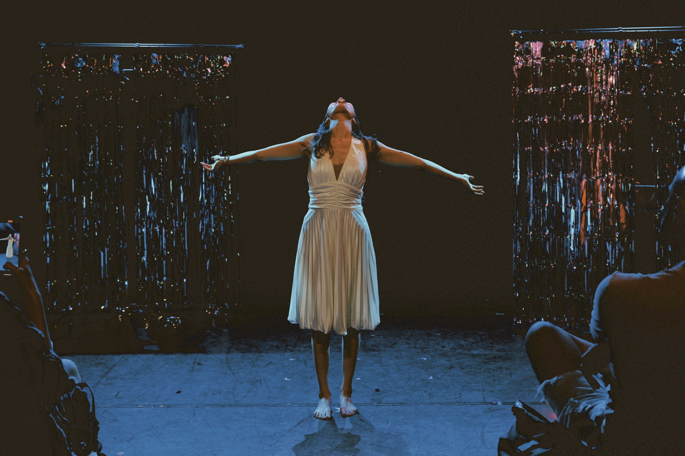 Feride standing in a white dress with her arms open during Chickadee